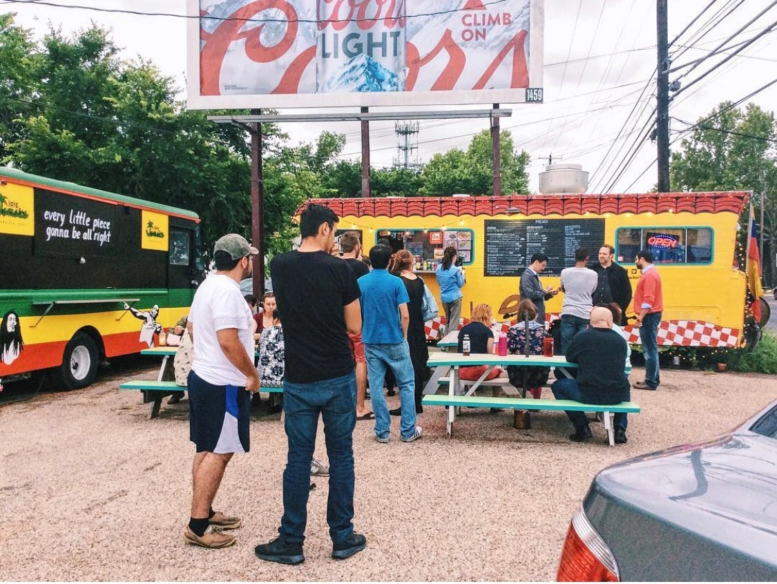 People gathered around the painted Four Brothers truck and picnic tables in 2015.