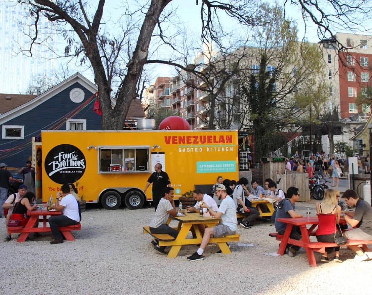 Our trailer with people gathered at picnic tables.